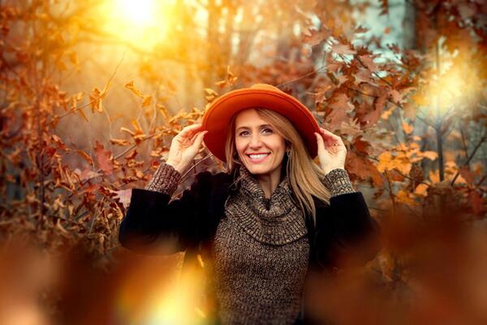 Smiling lady holding an orange sun hat