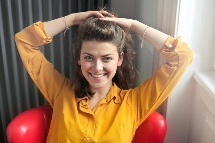 Woman wearing a yellow button-down, long-sleeved dress shirt