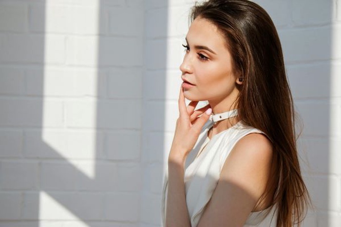 Woman in white top posing for photo