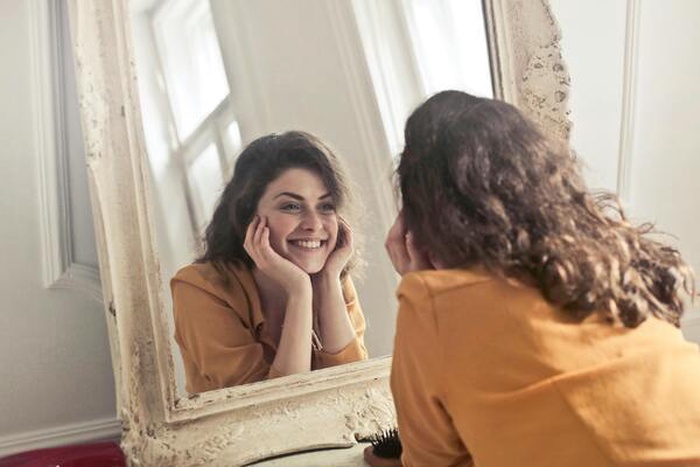 A photo of a woman looking in the mirror